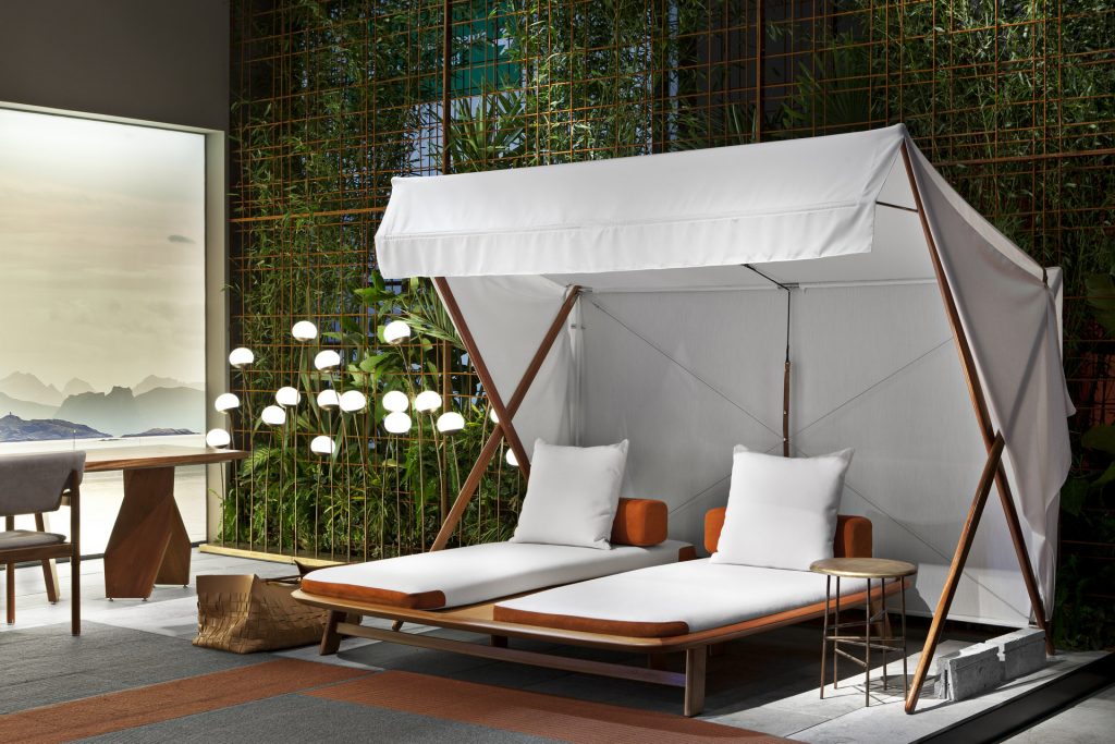 10th Tellaro Sun Lounger: White cushioned sun lounger with an adjustable backrest and wooden frame in a showroom.