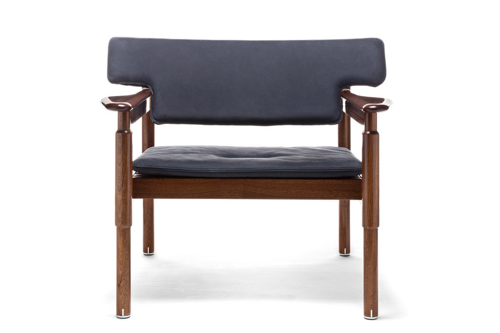 Vieste Armchair: Wooden armchair with a gray cushioned seat with four legs on a white background.