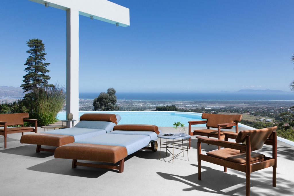 Two Vieste Armchairs: Wooden armchair with a gray cushioned seat with four legs on a terrace.