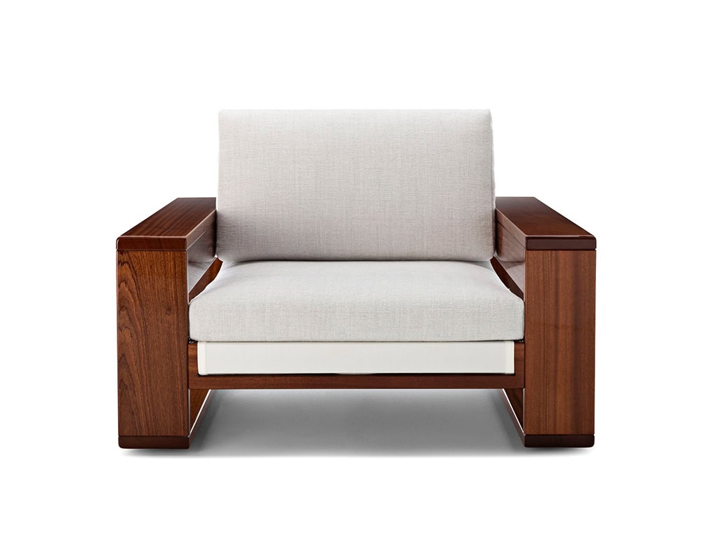 A Bellagio Outdoor Armchair with a dark wood frame and plush white cushions is captured at a low angle, emphasizing its modern design against a clean white backdrop