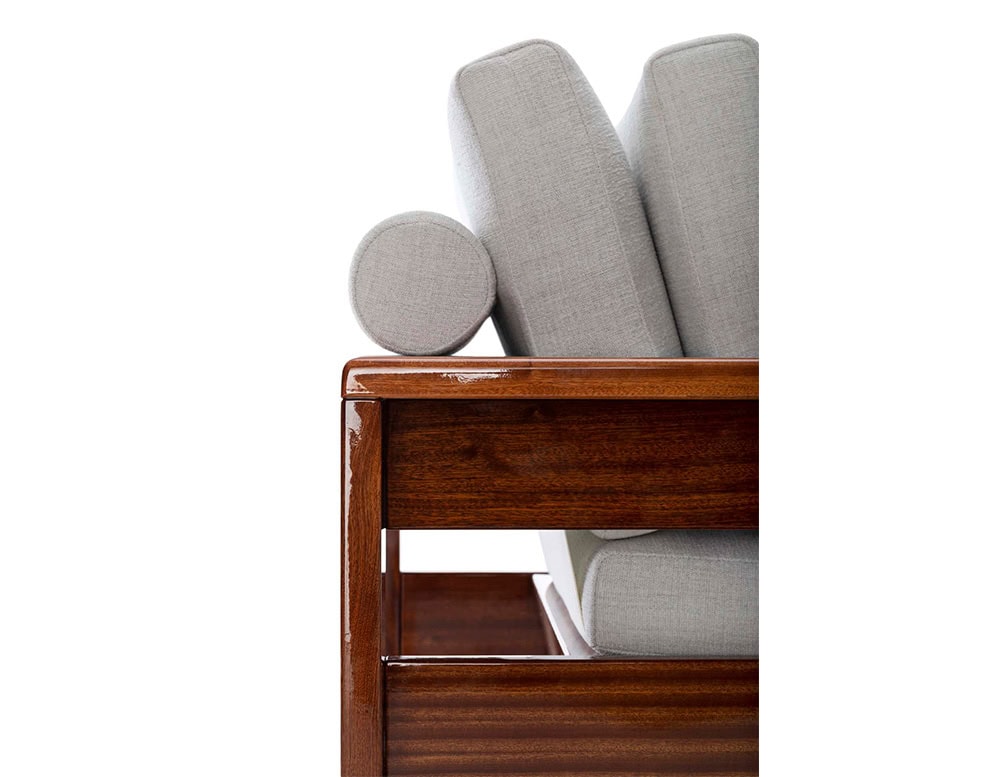 A close-up of a Bellagio Outdoor Armchair shows a wooden armrest and back with light-colored cushions against a white background