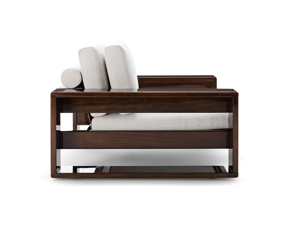 A side view of the Bellagio Outdoor Armchair showcasing its sleek polished wooden frame plush light-colored cushions and modern elegant design