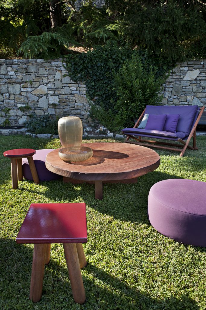 Individual Mini Round: Small round brown table with a slim central pedestal on a terrace.