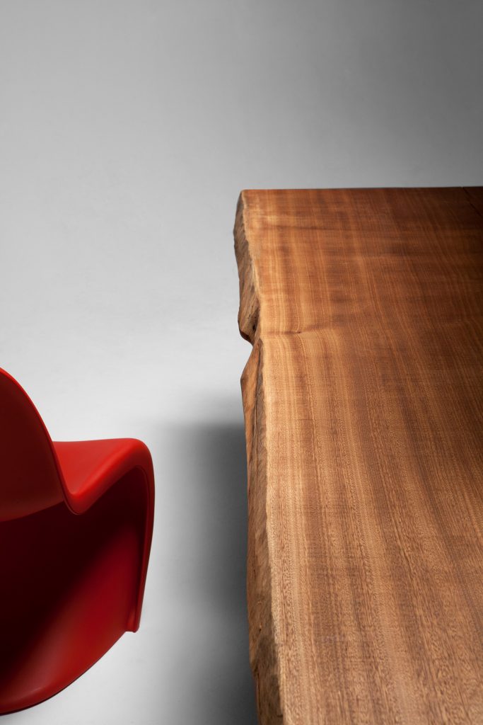 Closeup of Individual Table: Brown wooden rectangular dining table with two rectangular legs on a white background.