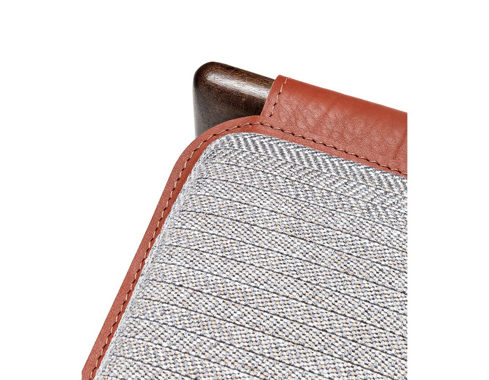 Closeup of Levante Chair. Structure in brown wood; seat in brown and gray cushion on a white background.