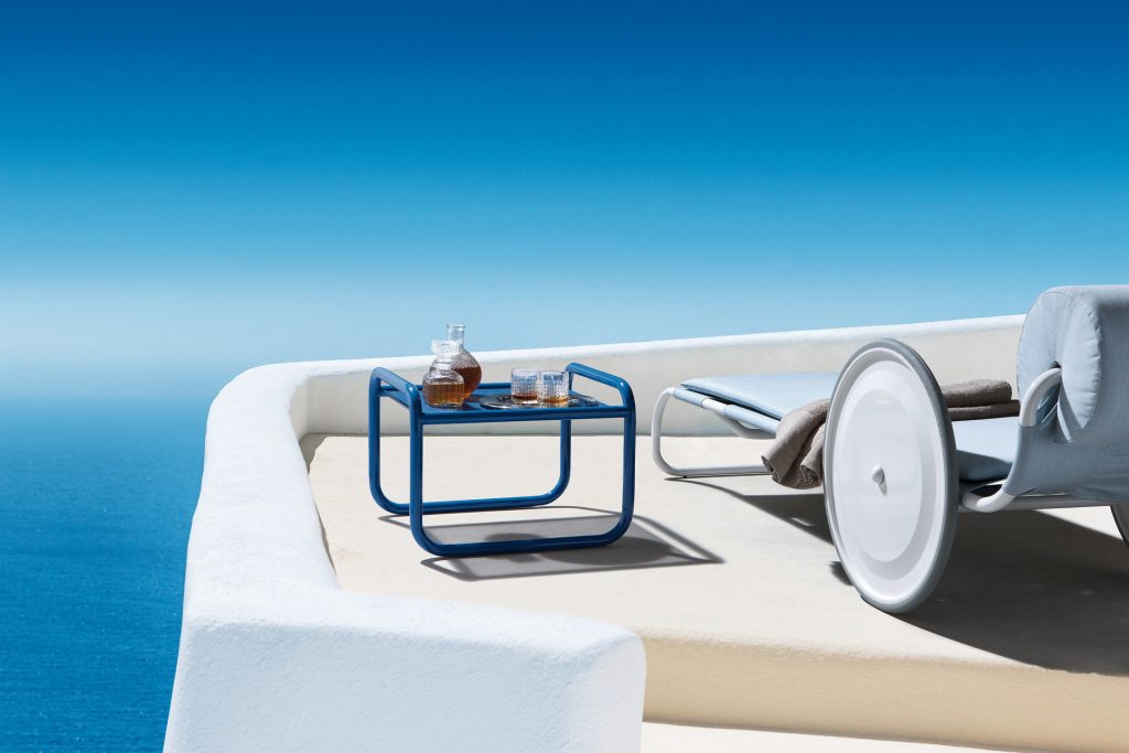 locus solus pouf in blue with an ocean view next to a sun lounger