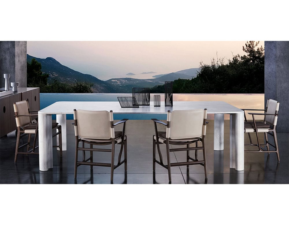 Michelangelo Dinner Table in rectangular shape. Top in white with gour gray legs on a terrace.