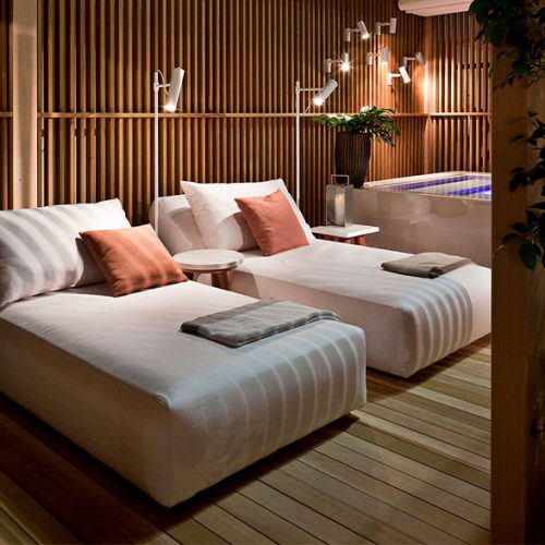 Two Montecarlo Sun Lounger in white fabric in a spa.