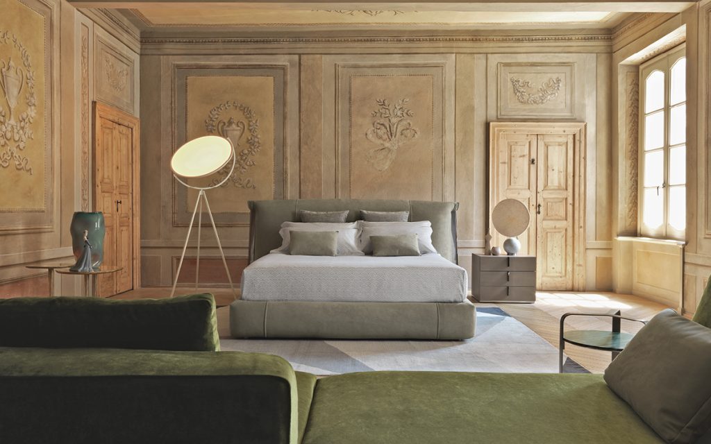 amal bed with dark green hearest in a distressed wood room setting