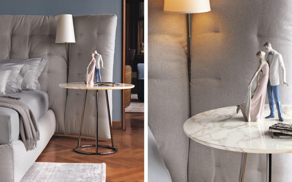 angle table in white marble next to a bed with 2 figurines about to kiss