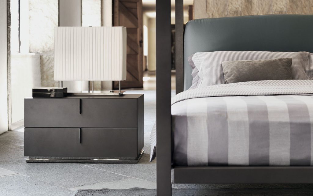 ari double bed in black with green backrest next to night table and lamp
