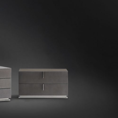 Two Ari Night Tables in black wood and handles, one with three and one with two drawers on a black background.