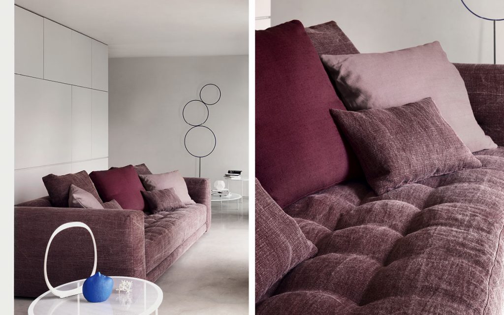 Closeup of Doze composition A sofa made of purple fabric with legs in a living room.