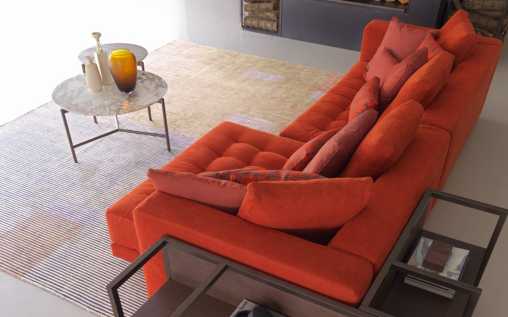 Short L shaped Doze composition B sofa made of red fabric with legs in a living room.