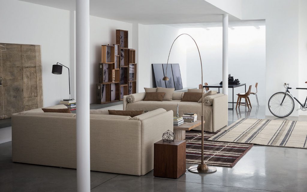 Two beige Duetto Transformable bed commpleted by seat cover, pillow covers and roll cushions in a living room.