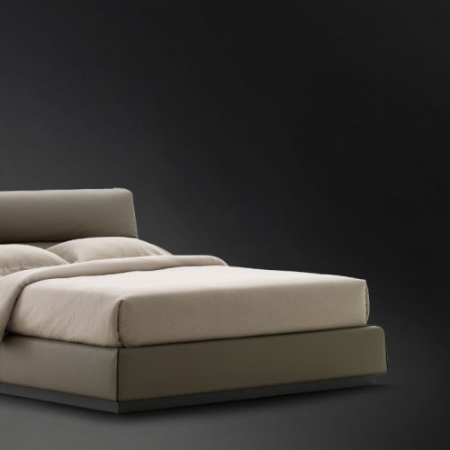 Gentleman Low. Base and high headboard upholstered in gray fabric with bedding on a black background.