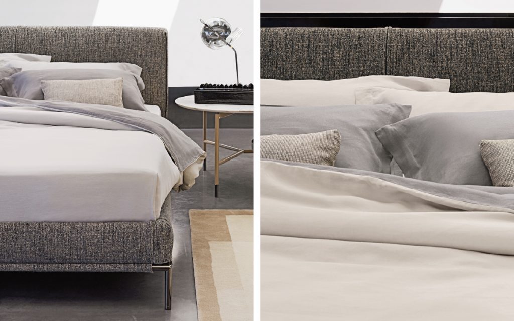 Closeup of Icon bed. Base and heardboard padded in gray fabric with black steel legs in a bedroom.