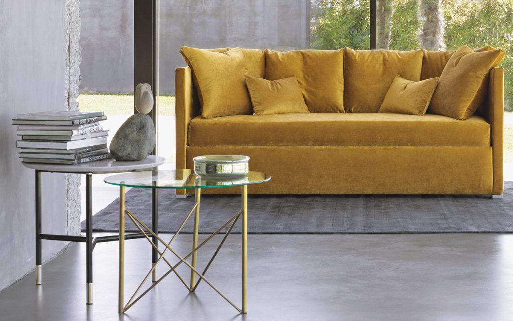 Iko Side Table, round top in white marble and three black legs in a living room.