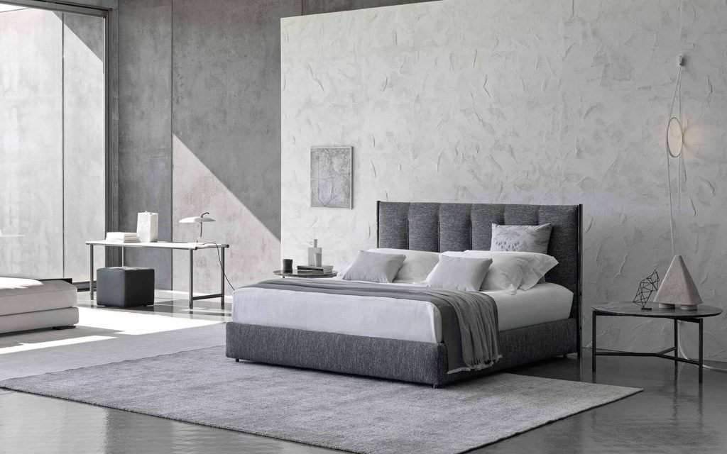Koi double size bed upholstered in gray fabric, heardboard with vertical lines pattern in a bedroom.