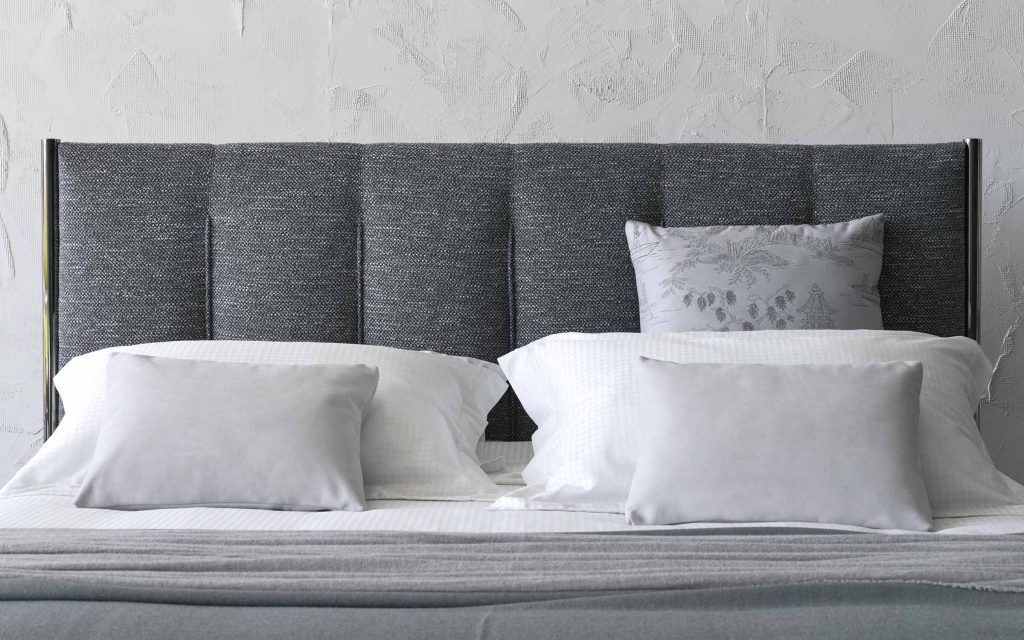 Koi double size bed upholstered in gray fabric, heardboard with vertical lines pattern in a bedroom.