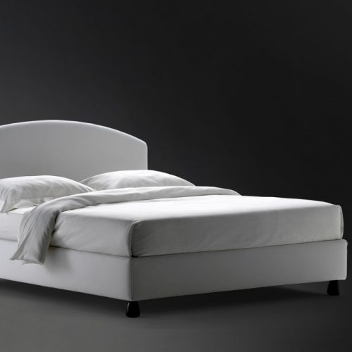Magnolia Double bed. Padded headboard and base with white fabric and black legs on a black background.