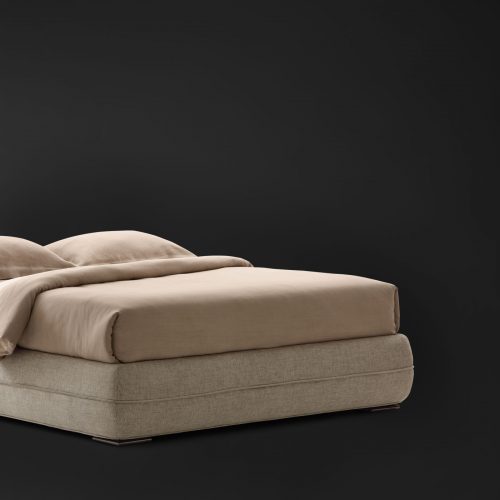 Mandarin Sommier in gray fabric and a mattress with bedding on a black background.