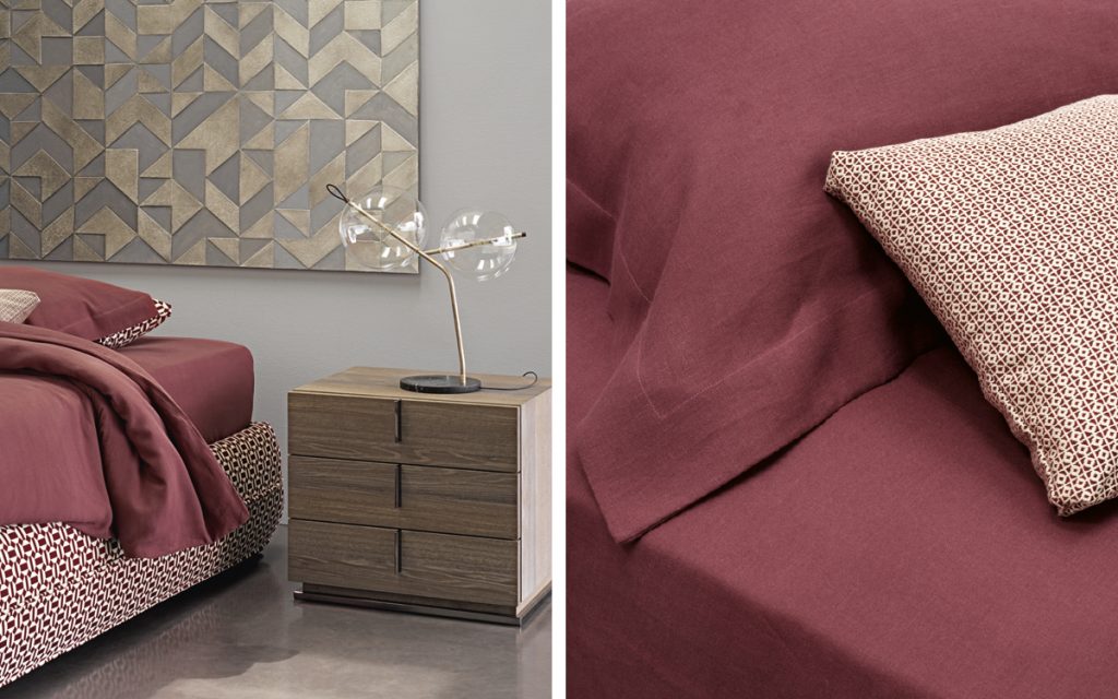Closeup of Mandarin Sommier in white and red fabric and a mattress with bedding in a bedroom.