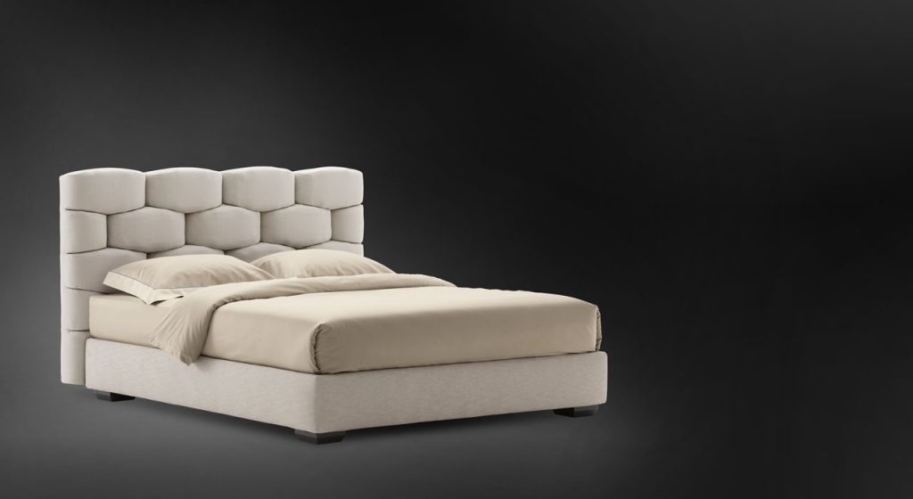 Beige Majal Double bed. Geometric shapes on the headboard and bedding on a black background.