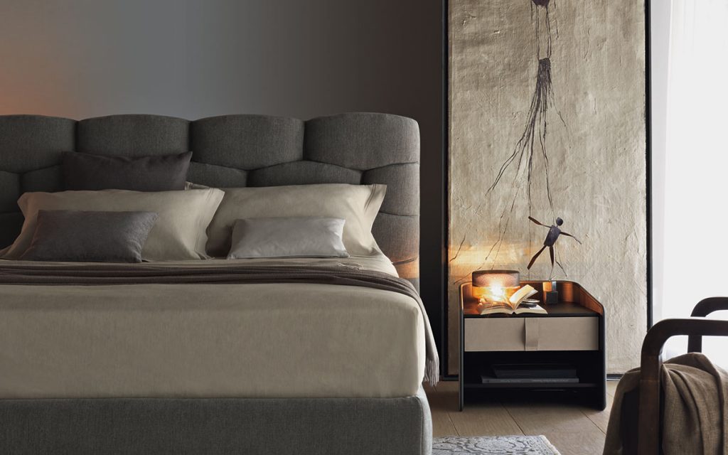 Gray Majal Double bed. Geometric shapes on the headboard and bedding in a bedroom.