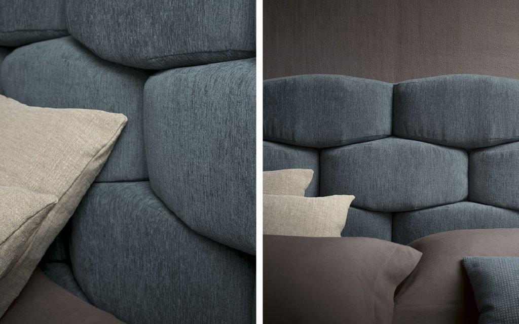 Closeup of blue Majal Double bed. Geometric shapes on the headboard and bedding in a bedroom.