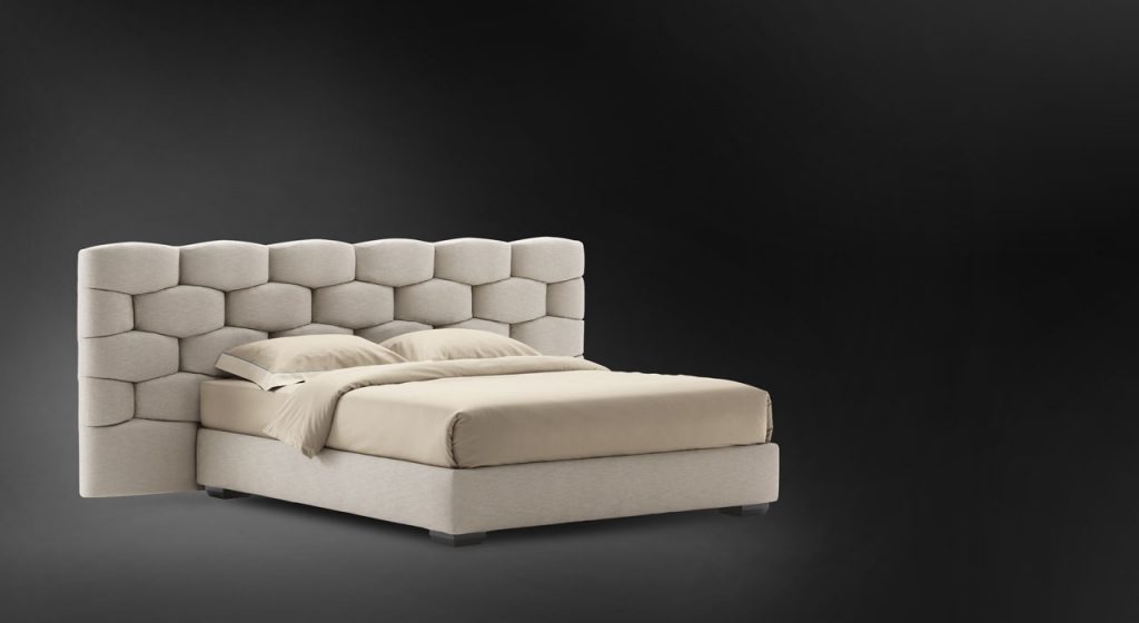 Beige Majal Wide bed. Geometric shapes on the headboard and bedding on a black background.