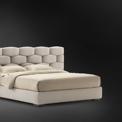 Beige Majal Wide bed. Geometric shapes on the headboard and bedding on a black background.