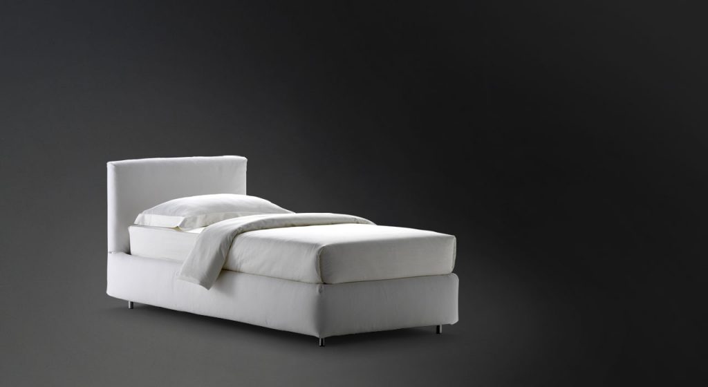 Merkurio Single bed. Base and headboard upholstered in gray fabric with legs on a black background.