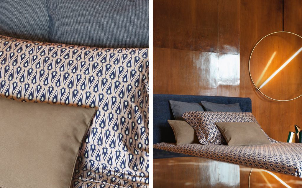 Closeup of Notturno Shabby Chic Bed. Base and backrest covered in blue fabric with bedding in a bedroom.