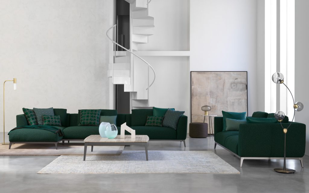 Two Olivier C sofas upholstered in green fabric and four legs in steel in a living room.