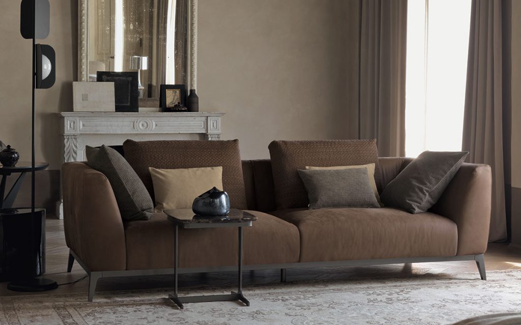 Olivier C sofa upholstered in brown fabric and four legs in steel in a living room.