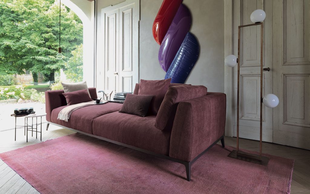Olivier D sofa upholstered in purple fabric and four legs in steel in a living room.