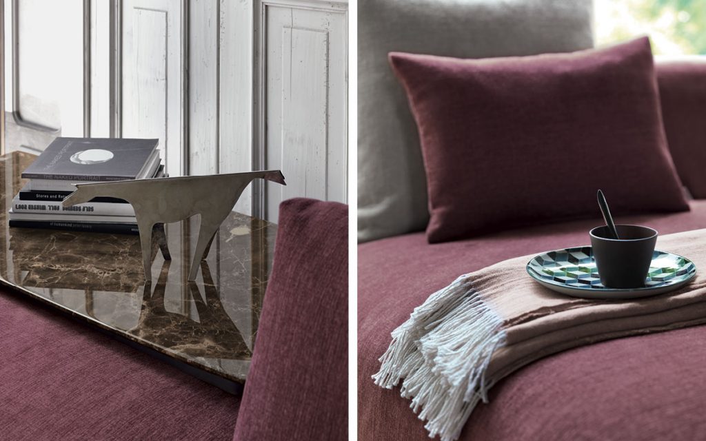 Closeup of Olivier D sofa upholstered in purple fabric and four legs in steel in a living room.