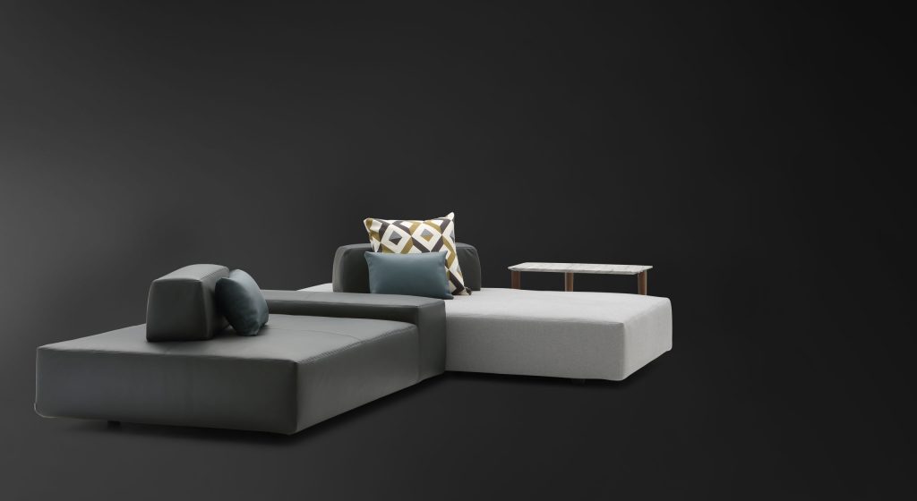 Two Softbench one hundred fifty three gray wide square modular sofas on a black background.