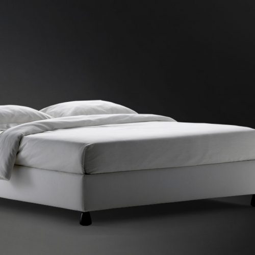 Sommier Double bed. Gray base with four black wheels and a mattress on a black background.