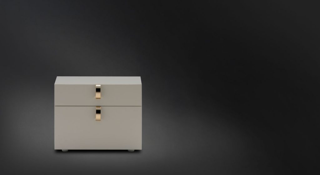 Square Splendor Night Table, structure in white with rectangle gold handles on a black background.