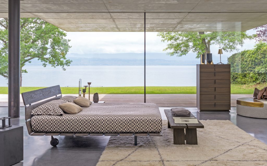 Tadao Double bed in brown oak. Structure and two legs in black in a bedroom.