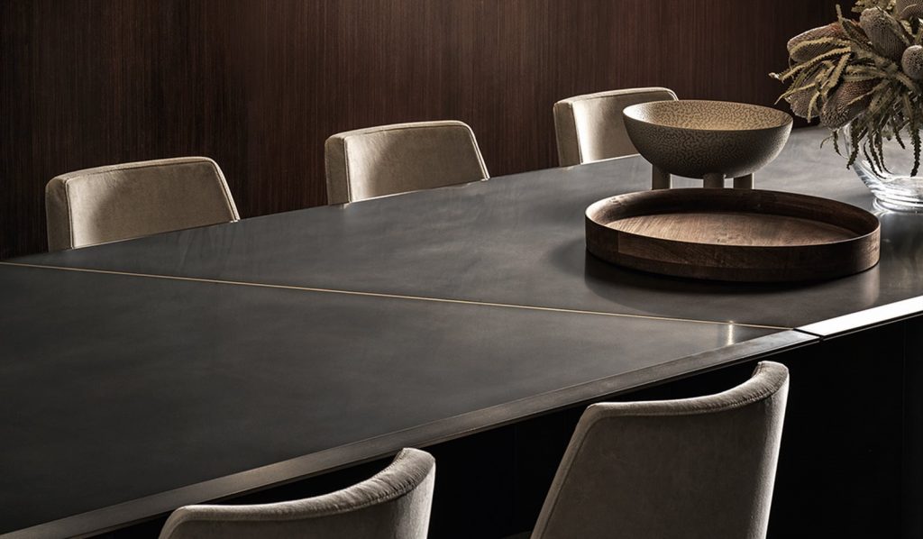 Large Platinium system table. Black rectangular shape with two legs in a dining room.