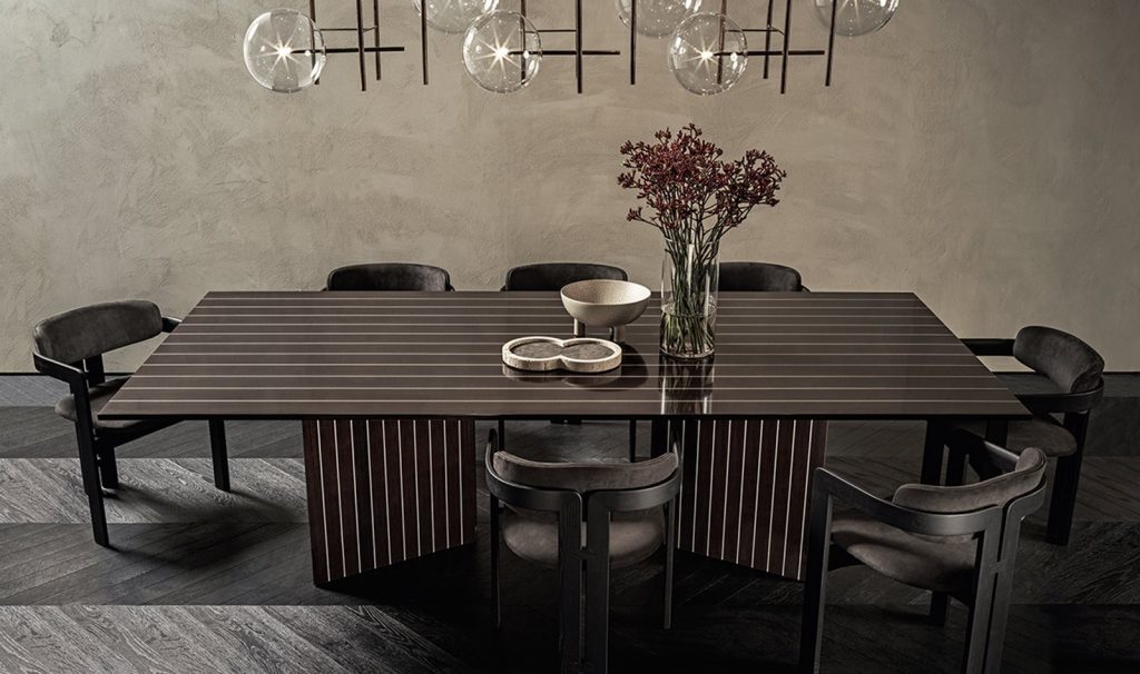 Prism rectangular dining tabe in brown wood with two legs in a dining room.