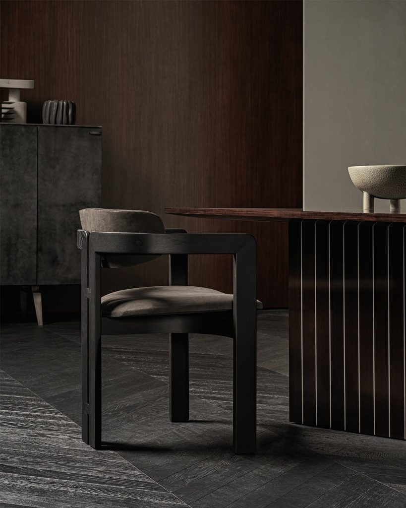 Closeup of a Prism rectangular dining tabe in brown wood with two legs in a dining room.