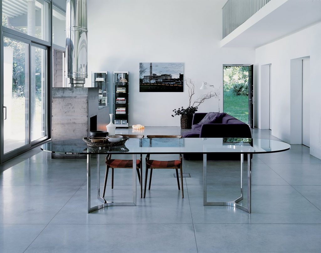 Raj / Raj Light Home: Large oval dining table with a glass top and silver metal frame in an office.