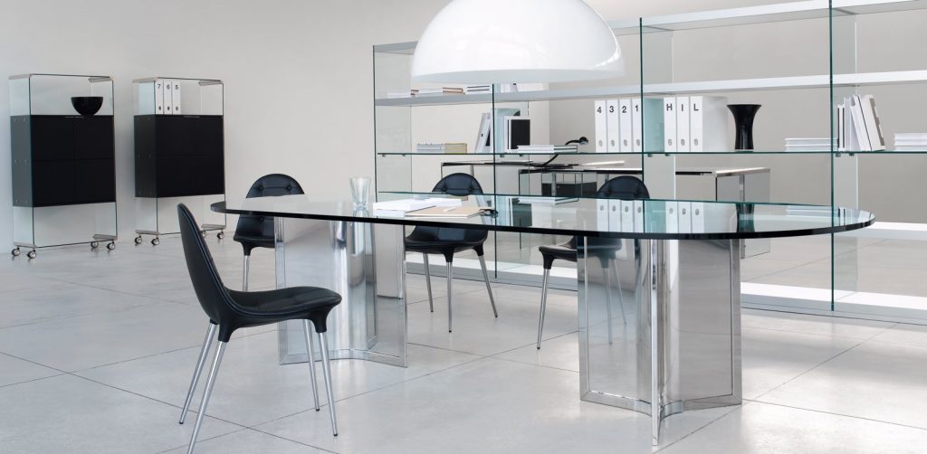 Raj / Raj Light Office: Large oval dining table with a glass top and silver metal frame in an office.