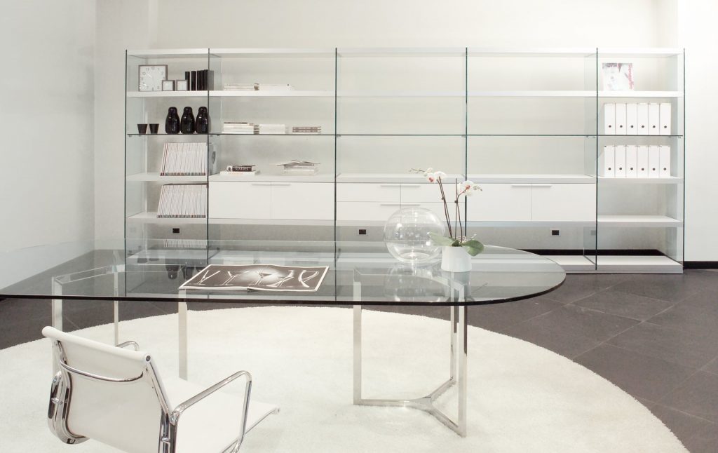 Raj / Raj Light Office: Large oval dining table with a glass top and silver metal frame in an office.