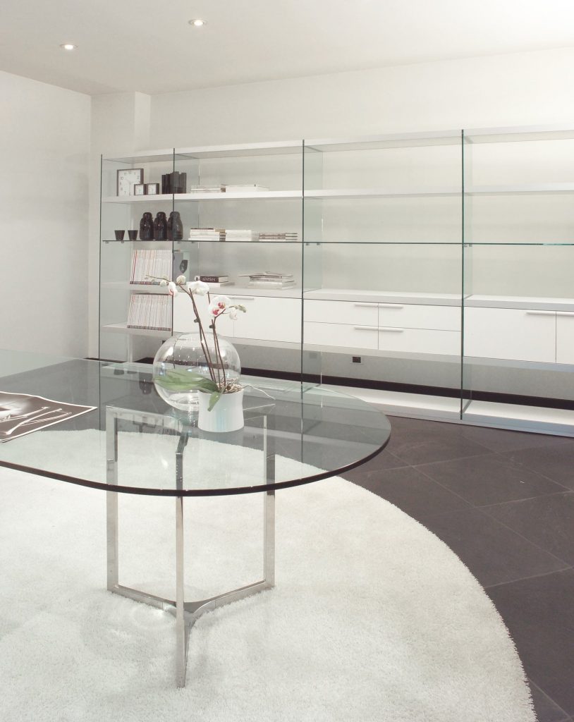 Raj / Raj Light Office: Large oval dining table with a glass top and silver metal frame in an office.