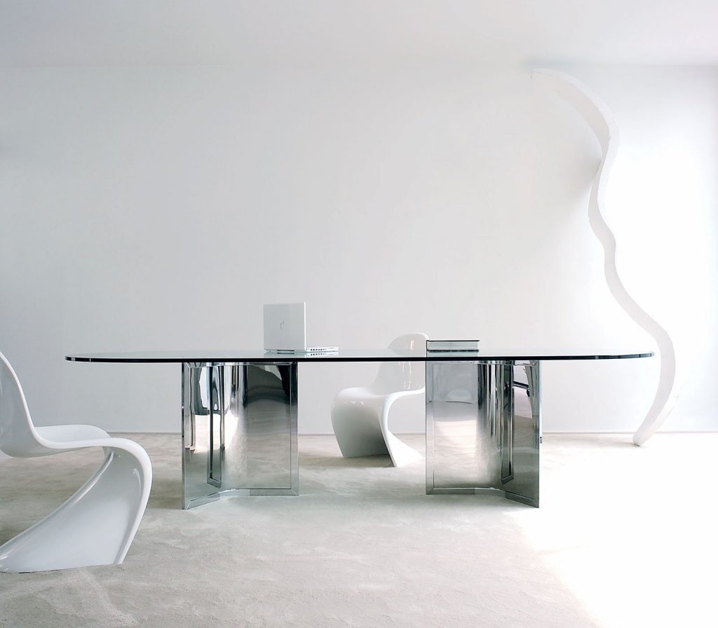 Raj / Raj Light Office: Large oval dining table with a glass top and silver metal frame in an office.